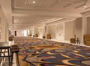 Pre-Function Corridor With Wall Art, Tables, and Chairs Outside of Meeting Space