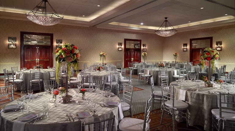 Ruang acara hotel yang diatur dengan meja bundar dan kursi