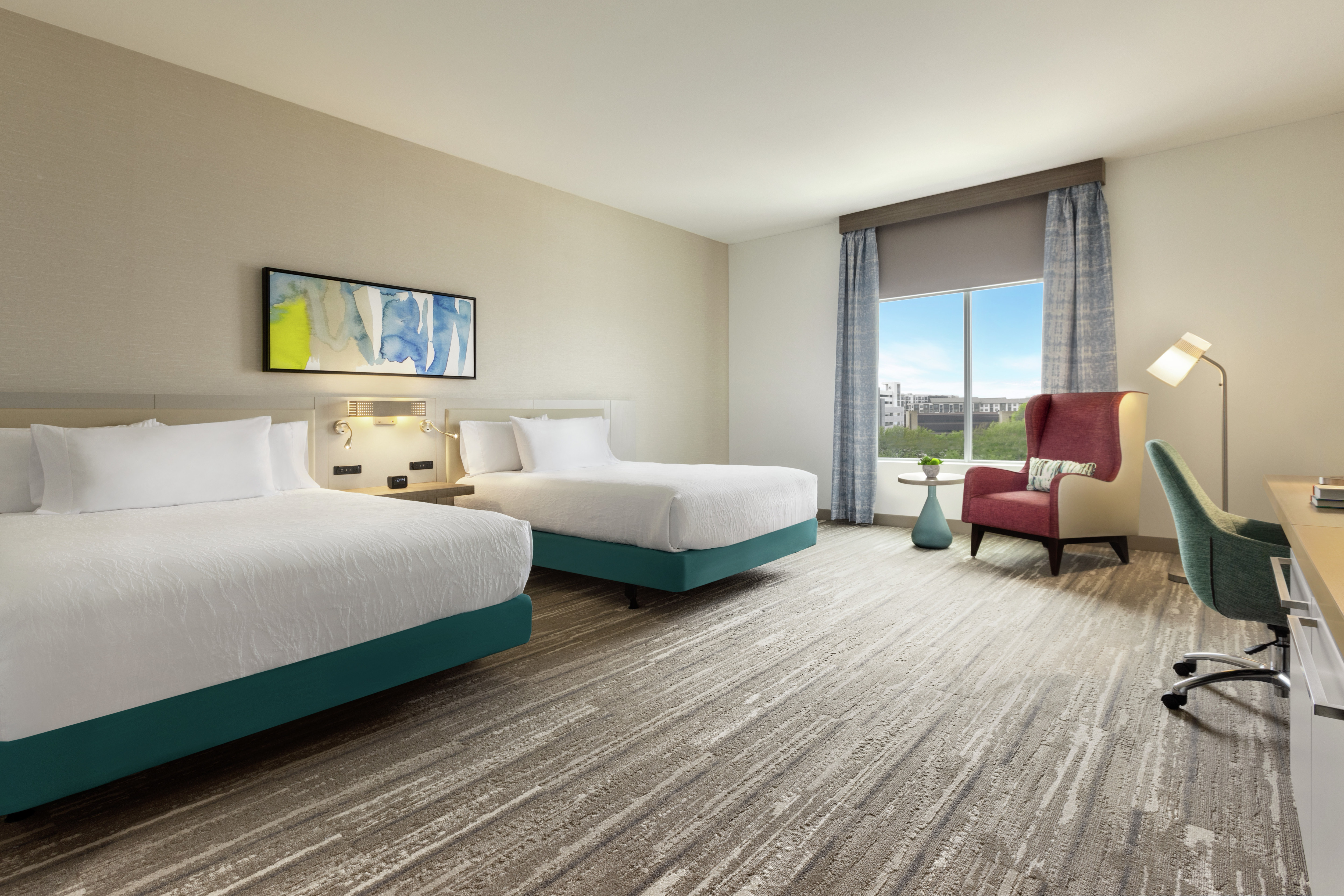 Spacious accessible guest room featuring two comfortable queen beds, work desk, and stunning outside view.