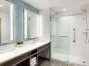 Spacious suite bathroom featuring large vanity with double sinks, light up mirrors, and rain shower.