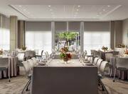 Spacious meeting room featuring wedding setup with beautiful floral center pieces and ample seating.