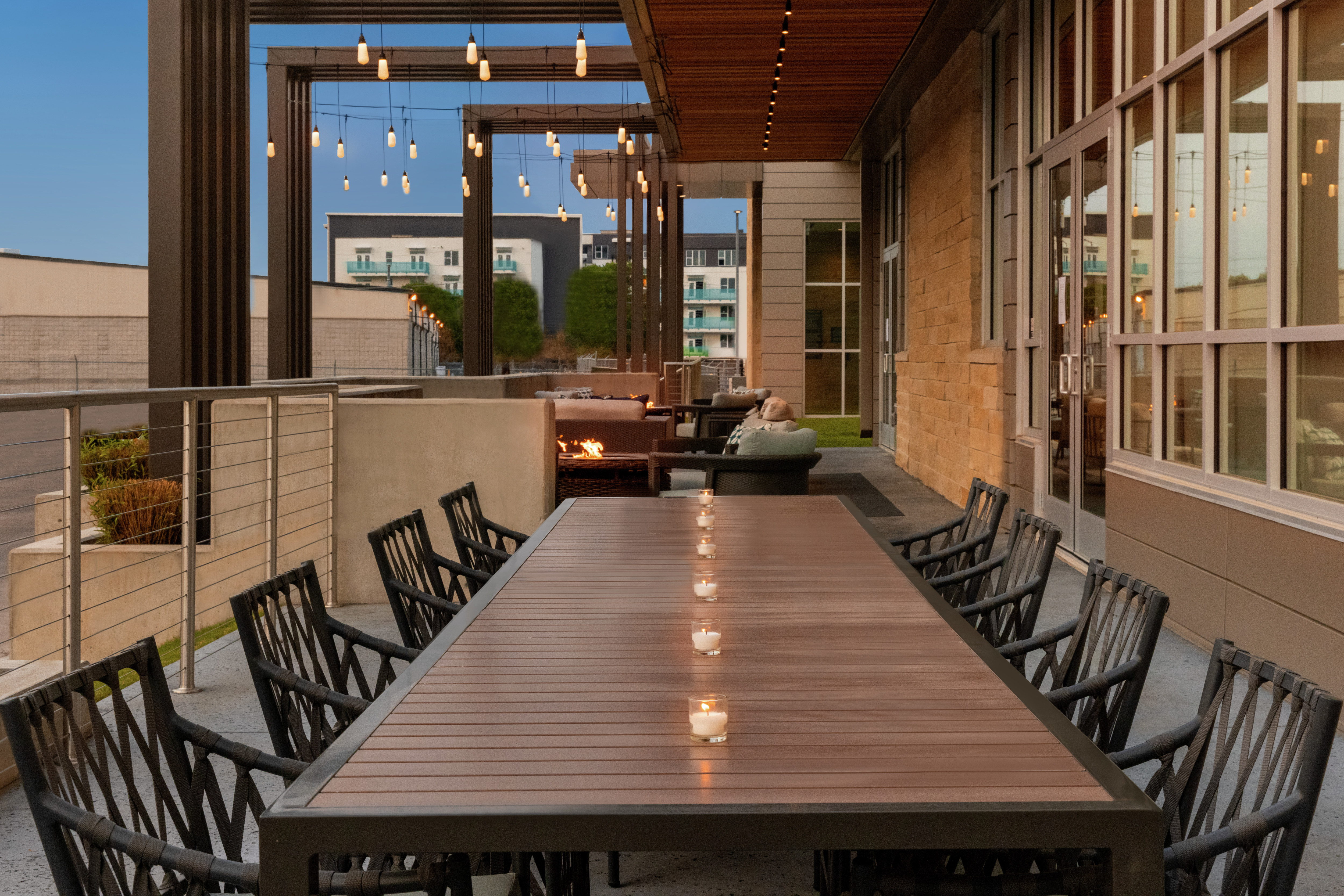 Beautiful outdoor patio area for guests to relax featuring large table set with candles.