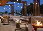 Spacious outdoor patio area featuring beautiful string lights, comfortable seating, and firepits. 