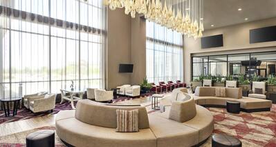 Bright hotel atrium featuring high ceilings, stunning design, and ample comfortable seating for guests.