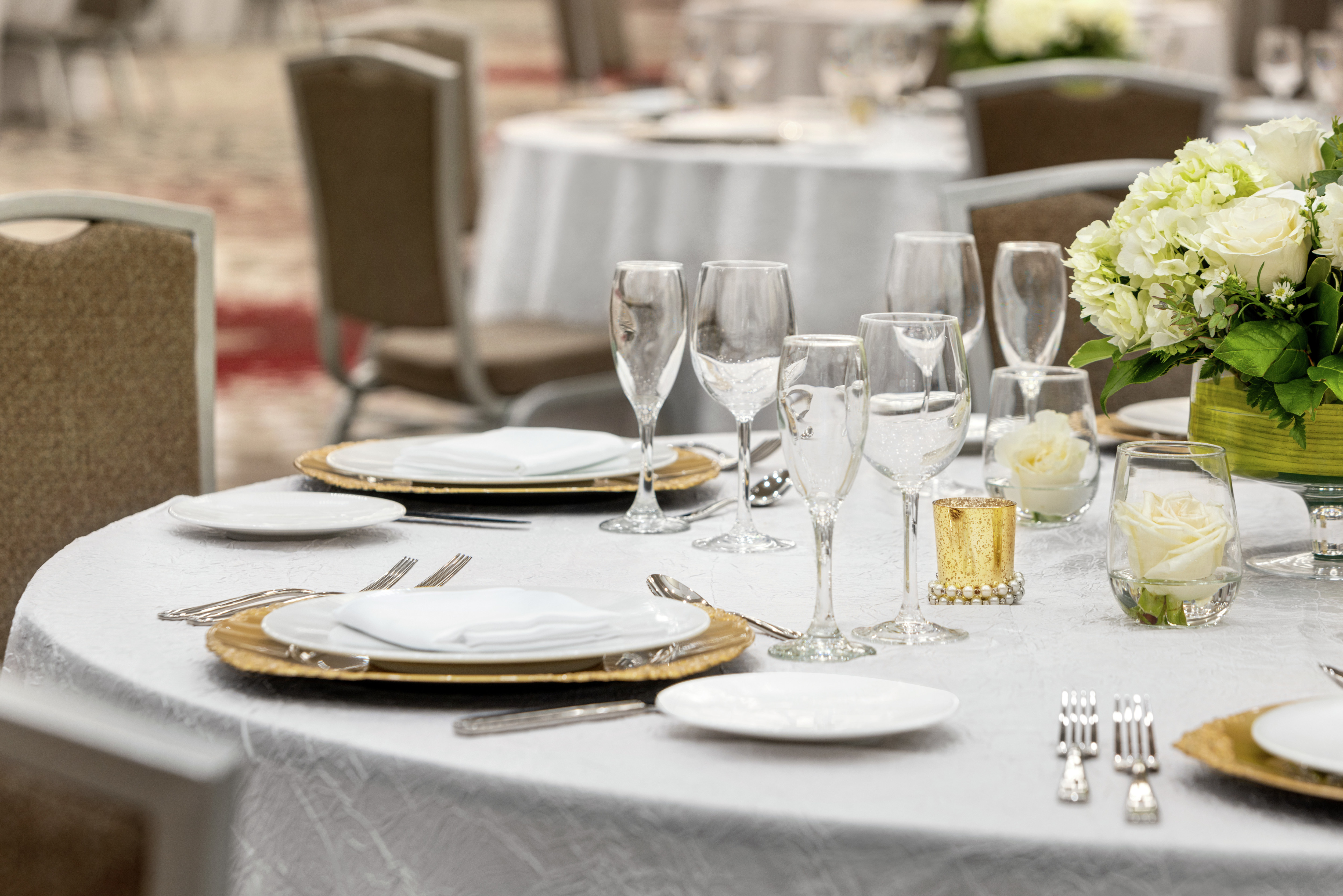 Spacious on-site ballroom featuring wedding setup with stunning table design.