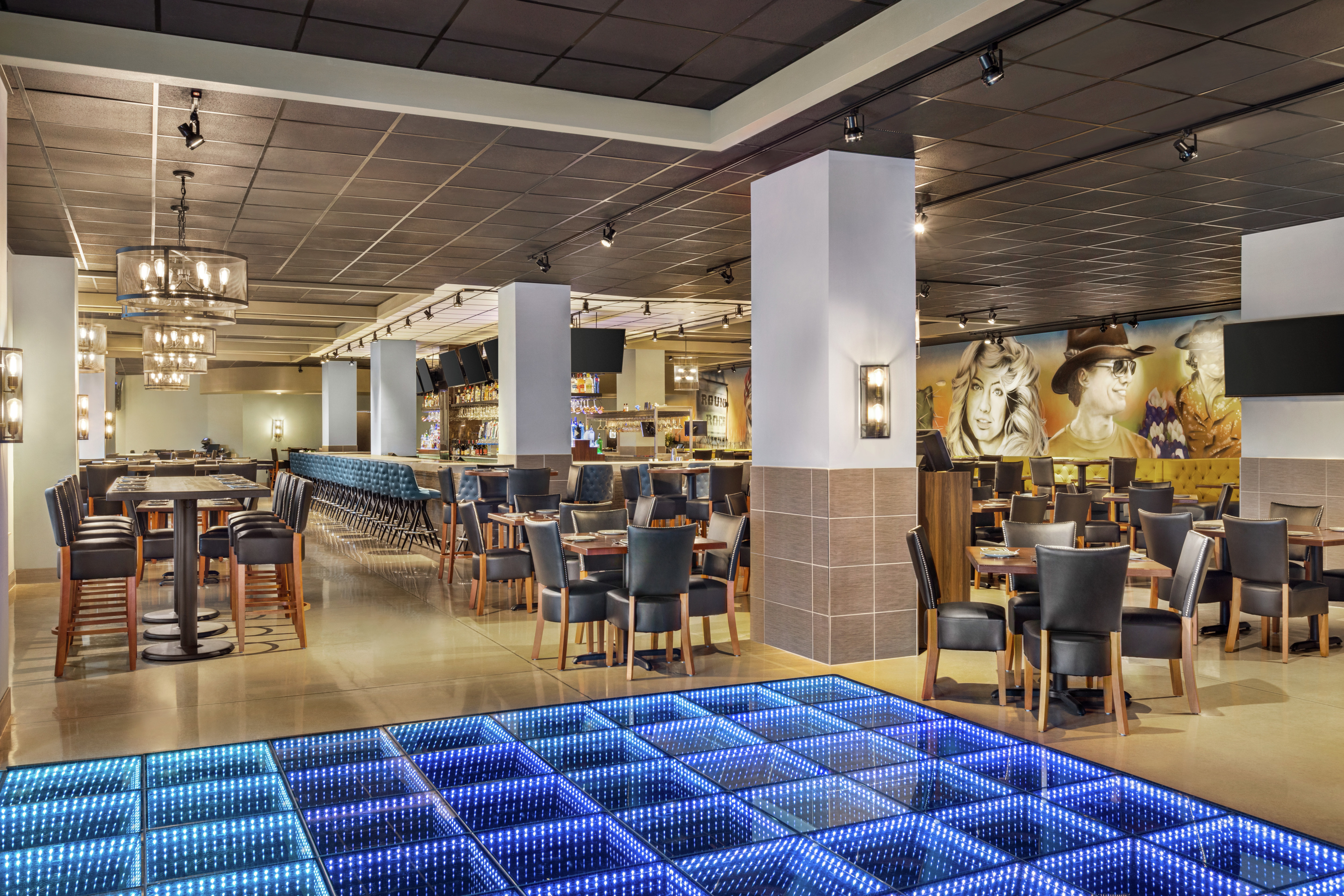 Spacious on-site restaurant and bar featuring fun design, ample seating, and eye catching wall mural.