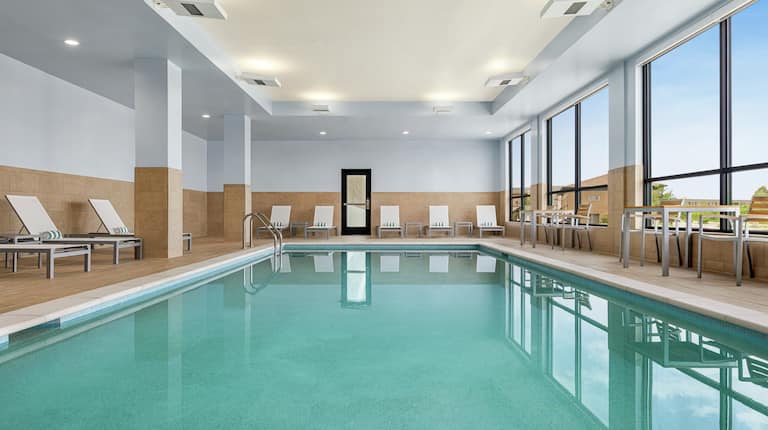 Spacious indoor pool featuring ample seating and large bright windows.