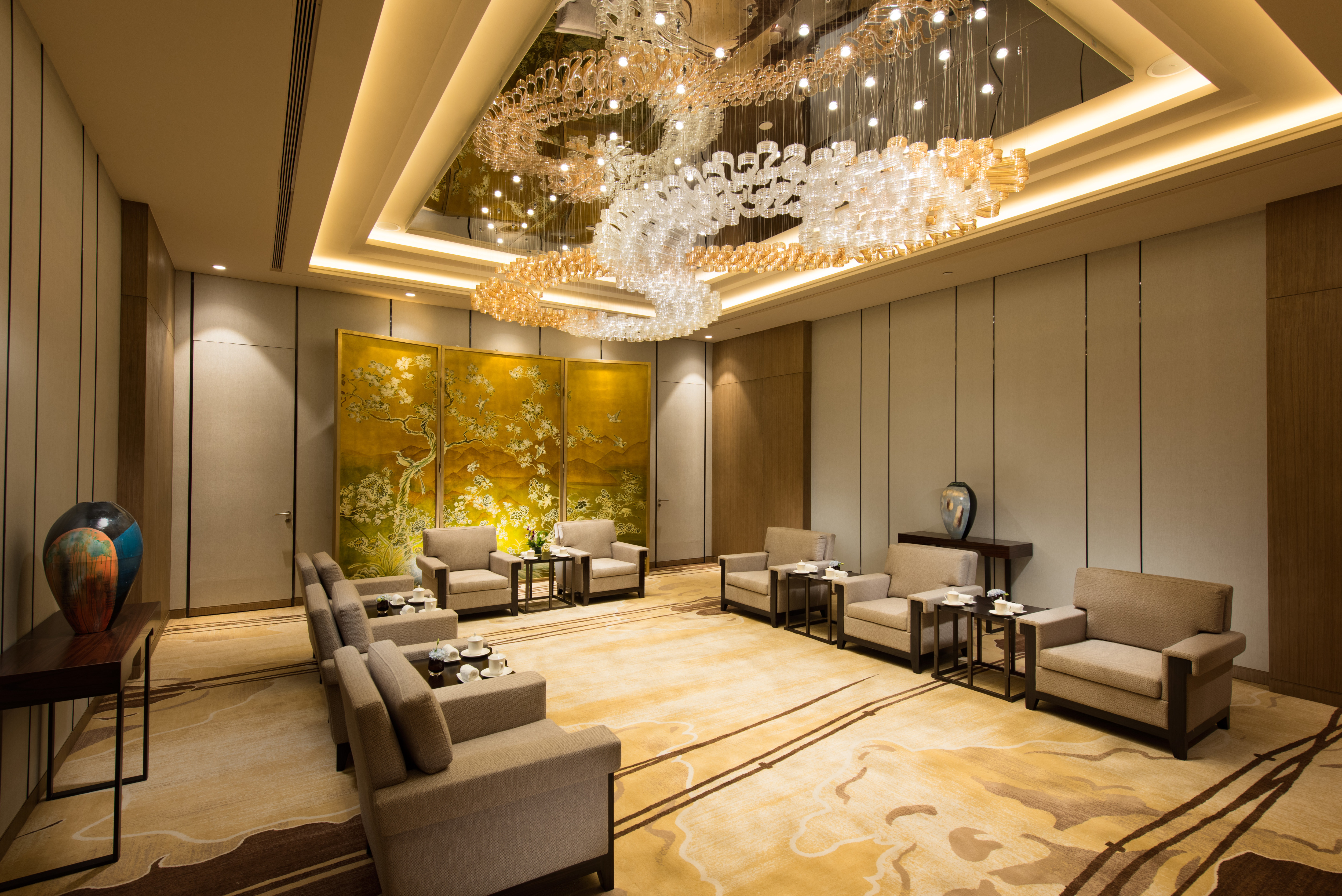 Lounge Area of VIP Room With Soft Seating, Decorative Lighting, and Large Wall Art Feature