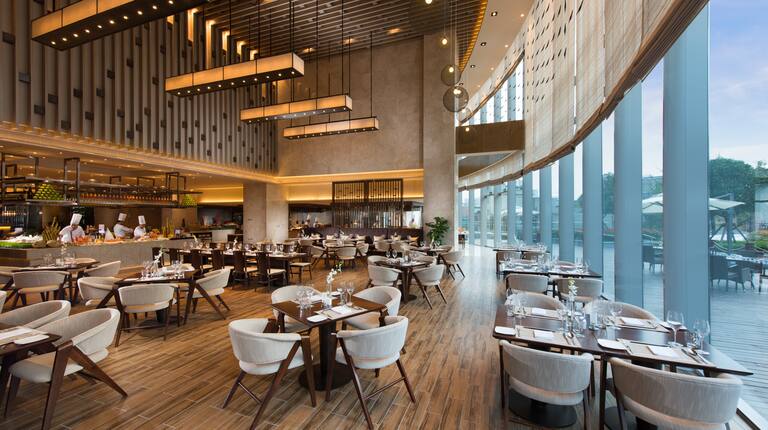 Decorative Lighting, Large Windows With View, Three Chefs in Food Service Area, and Dining Seating Options