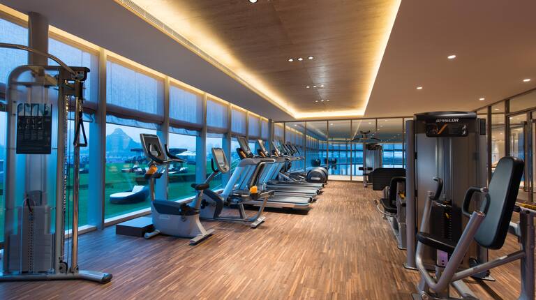 Fitness Center With Cardio Equipment by Large Window With Mountain View