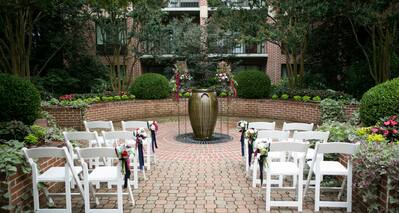 White Chairs Decorated with Flowers for and an Event on Outdoor Patio