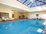 Indoor Pool and Spa With Skylight and Poolside Chairs
