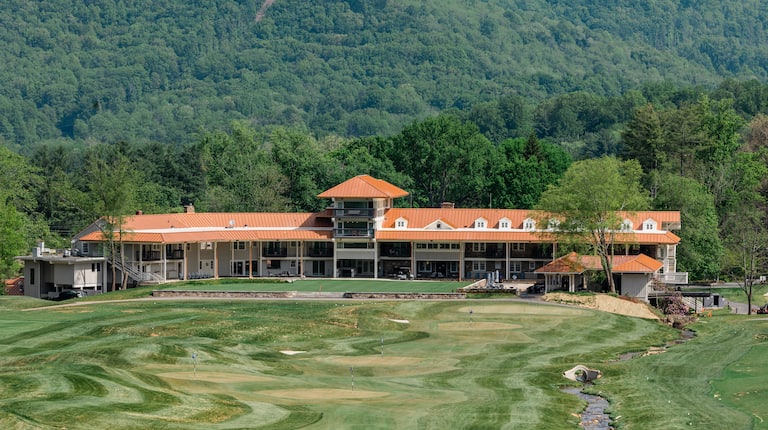 Birds eye view of the back exterior of the inn with two levels of accomodations and a portion of the golf course.