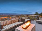 Outdoor Patio Seating Area with Sofas, Armchair and Firepit at Night