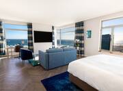 Suite Bed and Living Area with Panoramic Views of the City and Sea