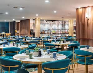 Área de comedor del restaurante Indigo con mesas redondas y sillas azules