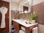 Executive Bathroom with Plush Robe and Illuminated Wall Mirror