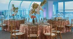 Close Up of Round Tables with Chairs, Place Settings, and Large Floral Arrangements Set Up for a Wedding Dinner/Reception