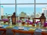 A Close Up View of the Place Settings, Lanterns, Decor and Glasses on a Banquet Table with a View Overlooking the Water