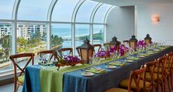 Banquet Setup in the Atlantic Ballroom with Chairs, Place Settings, and an Outside view of the Water Through Floor-to-Ceiling Windows