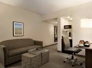 Full Length Mirror, Hospitality Center With Mini Fridge, Coffee Maker, and Microwave, Work Desk With Snack Tray, Illuminated Lamp, Ergonomic Chair, Ottoman, and Wall Art Above Sofa