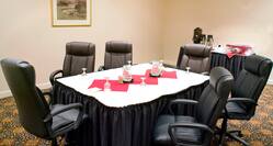 Boardroom With Wall Art, Seating for Six Around Table, and Beverage Station in Back