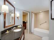 King Suite Guestroom Bathroom with Mirror, Vanity, Bathtub, and Shower