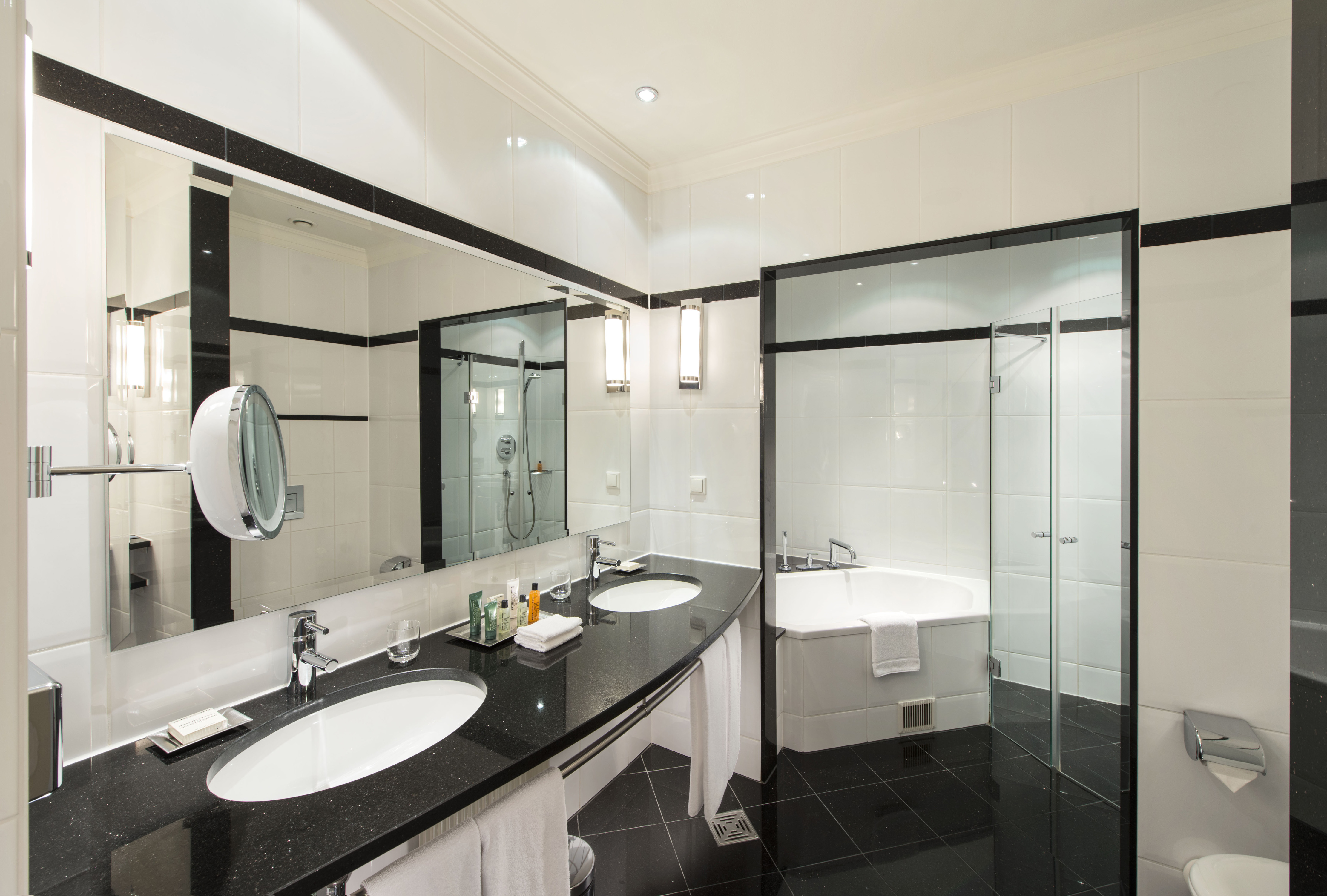 Badezimmer der Dome Suite mit Toilettentisch, Waschbecken, Spiegeln, Badewanne und Dusche
