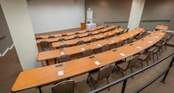 Classroom Setup in Serling Room With Overhead Projector, Tables and Chairs Facing Speaker's Table, and Podium