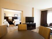 Double Queen Bed, TV, Sofa, and Dining Table in Suite