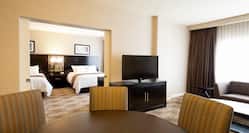Double Queen Bed, TV, Sofa, and Dining Table in Suite