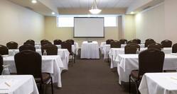 Classroom Setup in Endicott Room With Tables and Chairs Facing Presentation Screen
