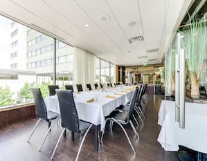Chairs and Long Dining Table with Place Settings on White Linen in River Bistro Private Dining Room