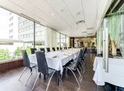Chairs and Long Dining Table with Place Settings on White Linen in River Bistro Private Dining Room