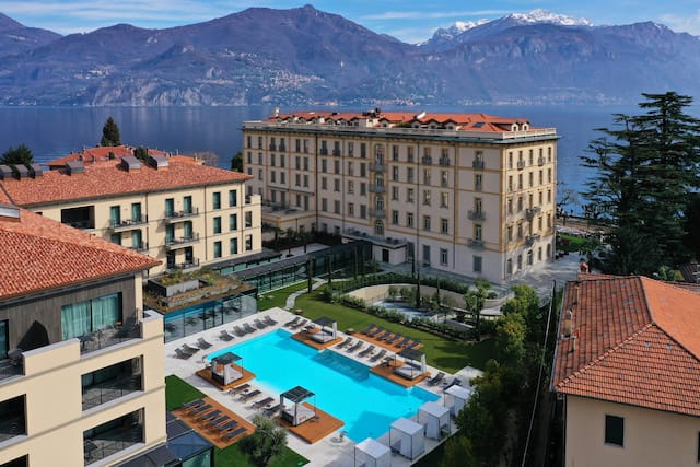 Aerial view of hotel and open air pool with lake and mountains in background