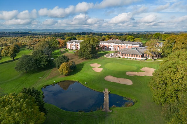 Birds eye view of the golf course and the exterior of the hotel.