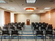 Meeting Room Set Up Theater Style With Rows of Black Chairs Facing Podium