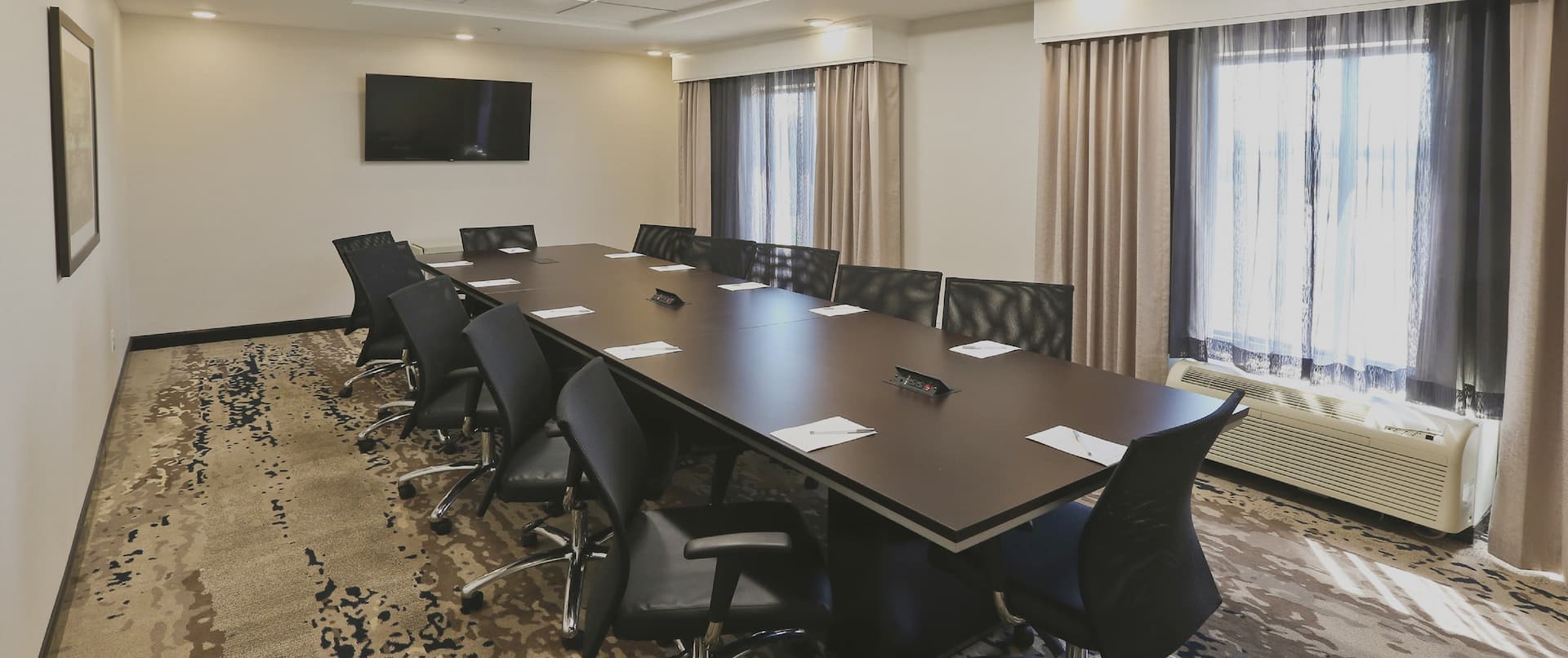 Boardroom with Large Table, Office Chairs and Wall Mounted HDTV