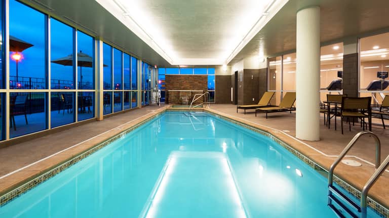 Indoor Swimming Pool With Lounge Seating and Windows