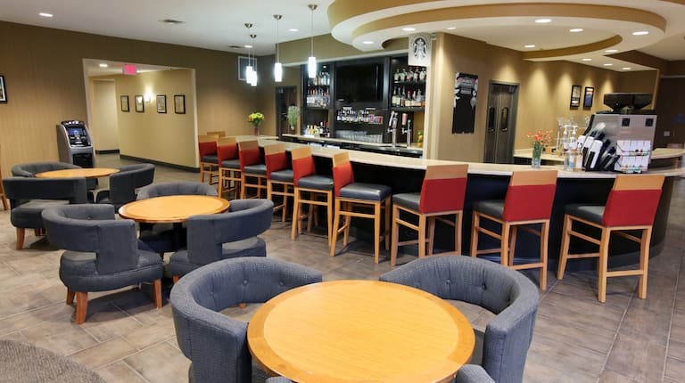 Round Tables With Blue Chairs and Red Chairs at Fully Stocked Bar of Lobby Restaurant and Lounge