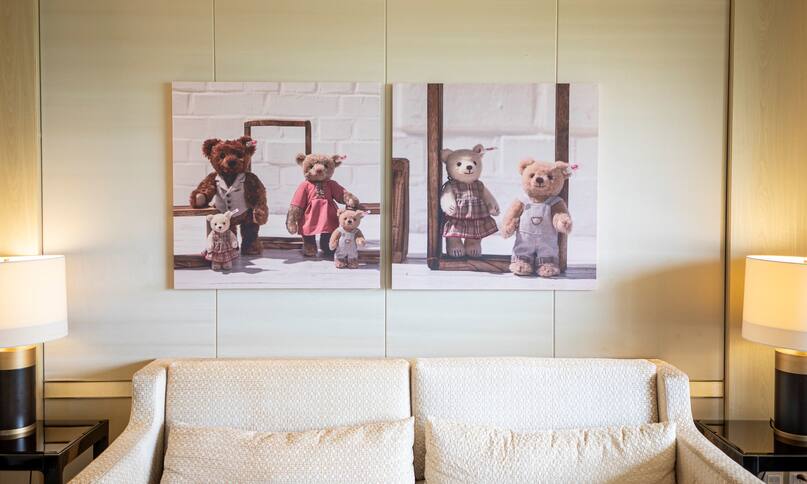 artwork of teddy bears over sofa in suite