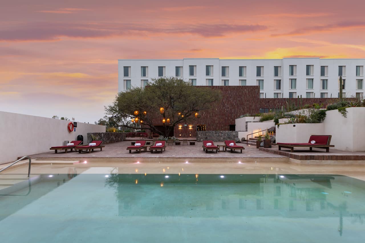 Outdoor Pool Area with View of Hotel Exterior at Sunset