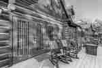 Exterior deck of guest cabin with rocking chairs and small tables