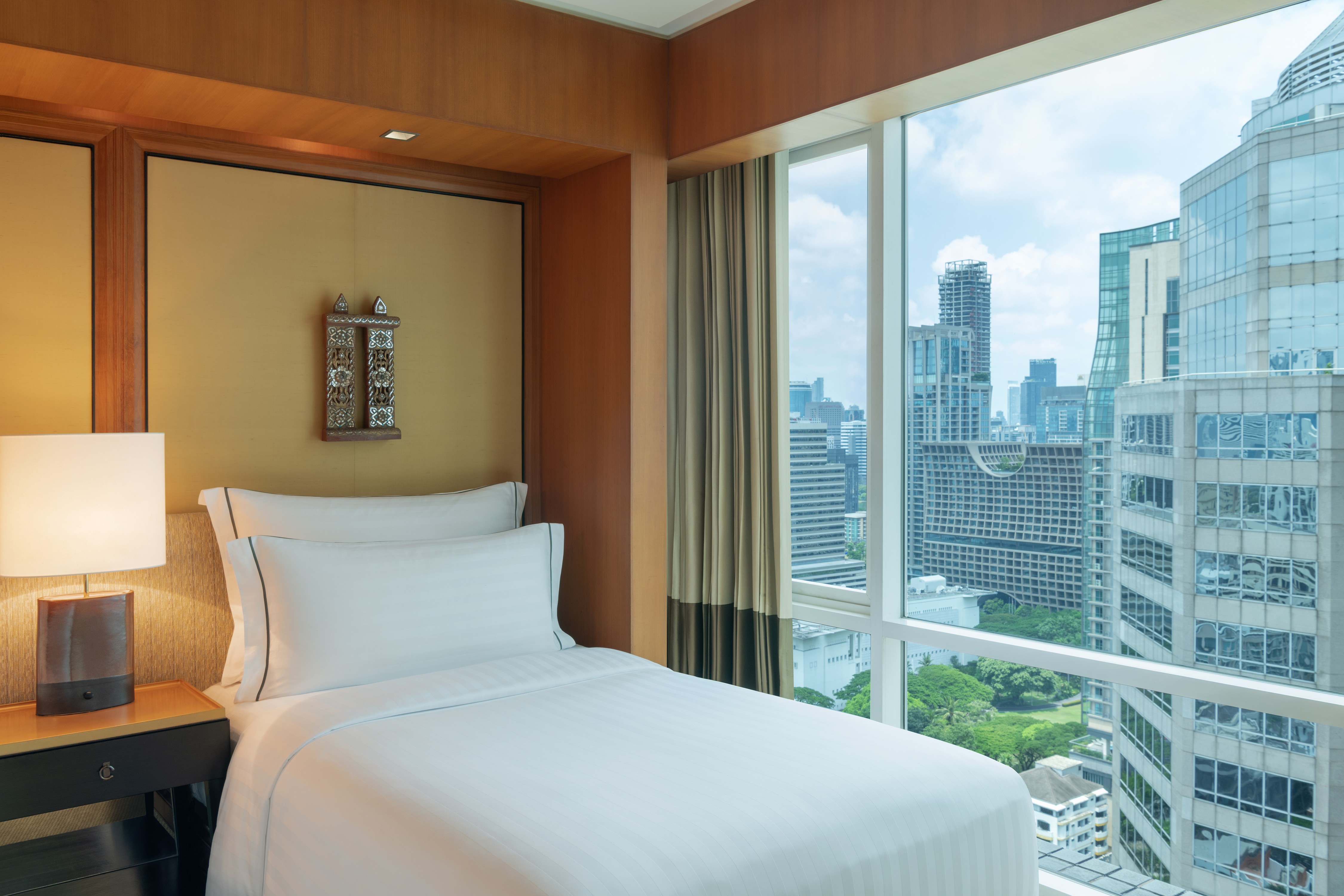 twin bed and window with view of city