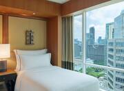 twin bed and window with view of city
