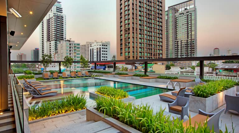 Outdoor Pool, Lounge Chairs, and City View at Sunset