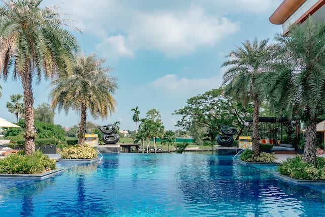 Outdoor pool with surrounding trees and statues