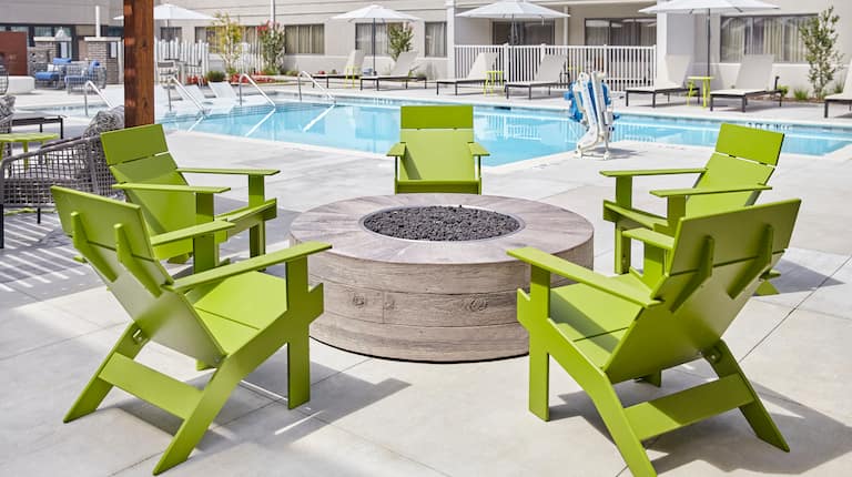 Outdoor firepit with pool and chairs