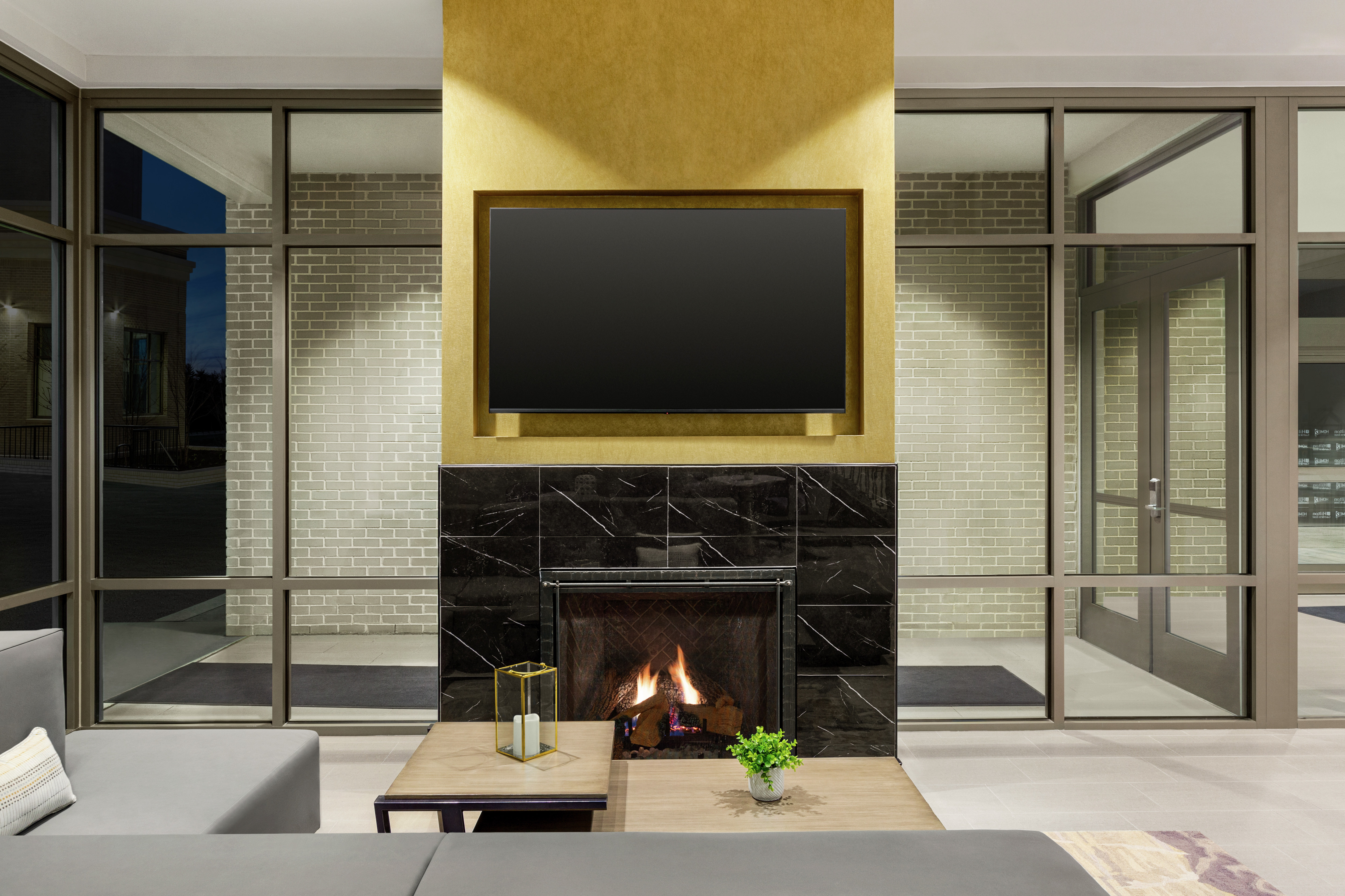 Beautiful hotel lobby featuring comfortable seating, TV, and fireplace.