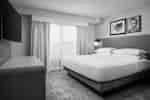 The head of a king bed with a nightstand next to it and a telephone sitting on it.